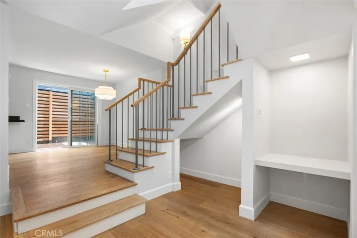 Wood floors with custom railing. Built in desk space, and under staircase space for dog bed or wine storage.