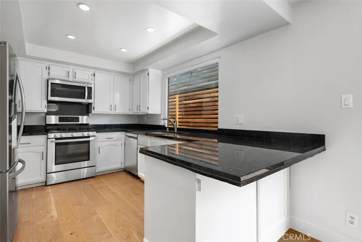 Kitchen has stainless steel appliances, dishwasher, granite countertops, and abundant cabinets & storage.