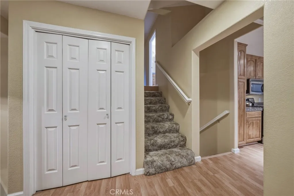 front entry closet downstairs to laundry room, garage, and primary bedroom with bathroom