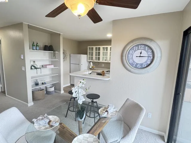 Dining area featuring a ceiling fan with integrated lighting, built-in shelving, and light-toned carpeting