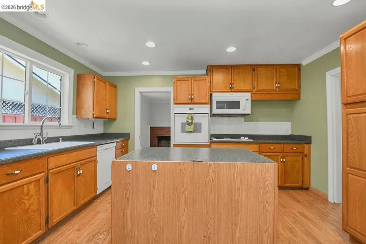 Central kitchen island with wood-finish paneling and dark countertop