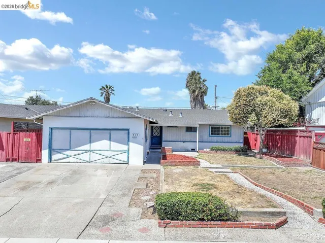 Single-story residence featuring an attached garage with a decorative door, a paved driveway, and a front walkway