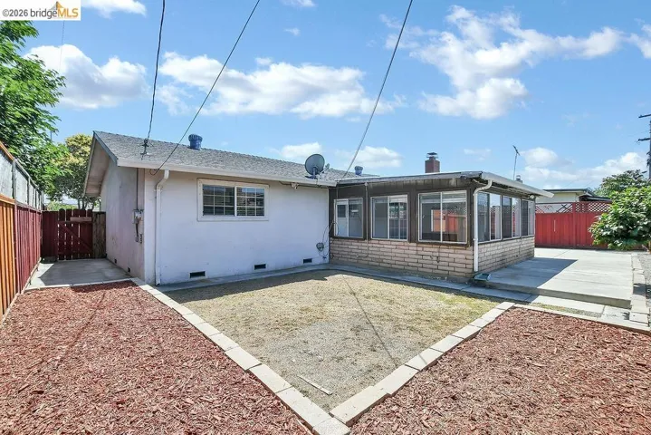 Rear exterior featuring a sunroom addition with a brick veneer base