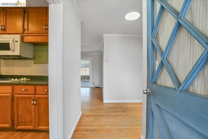 Entryway featuring a decorative paneled door, wood-finish flooring, and recessed lighting