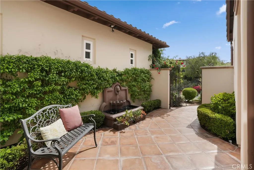 Private gated courtyard with tranquil fountain, decorative ironwork, and a welcoming outdoor sitting area.