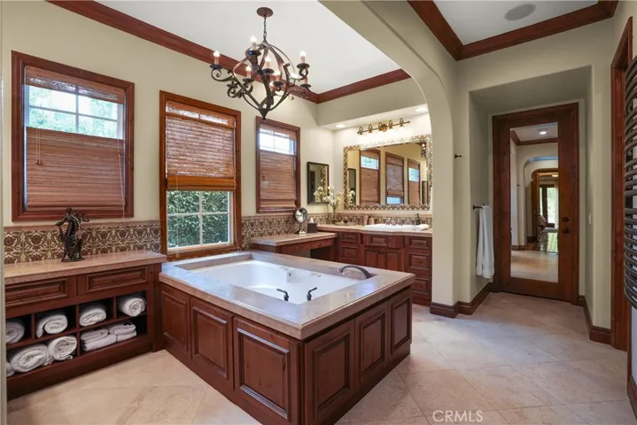 Spa-inspired primary bath with a soaking tub, dual vanities, separate makeup station, and custom cabinetry.