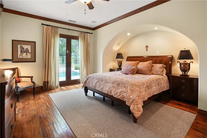 Private main-level primary suite with French doors providing direct access to the backyard retreat.