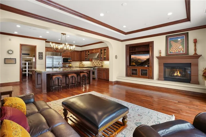 Open-concept family room with custom built-in media center, fireplace, and seamless connection to the kitchen.