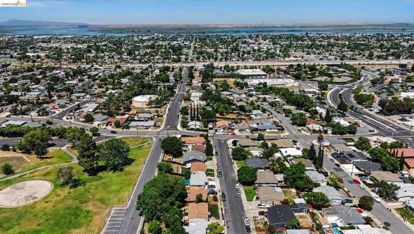 Aerial perspective showcasing a residential neighborhood with a large body of water in the background
