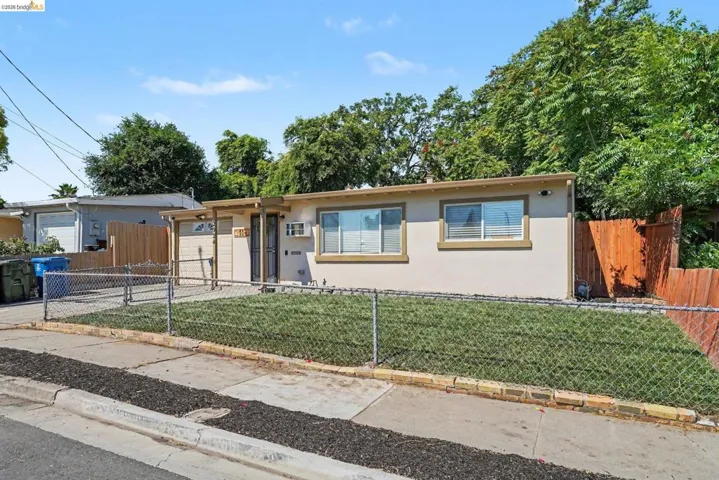 Single-story residence featuring a stucco exterior with multiple windows and a covered front entry