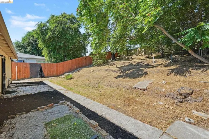 Backyard featuring a sloped, natural landscape with mature trees