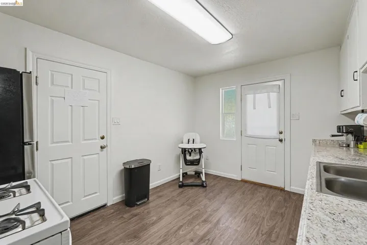 Kitchen area featuring wood-finish flooring, white walls, and a recessed ceiling light