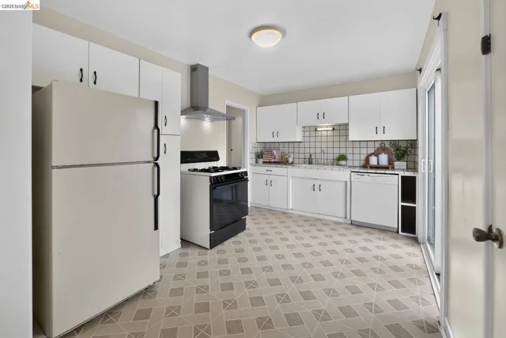 Kitchen featuring white cabinetry, a neutral tiled backsplash, and patterned tile flooring