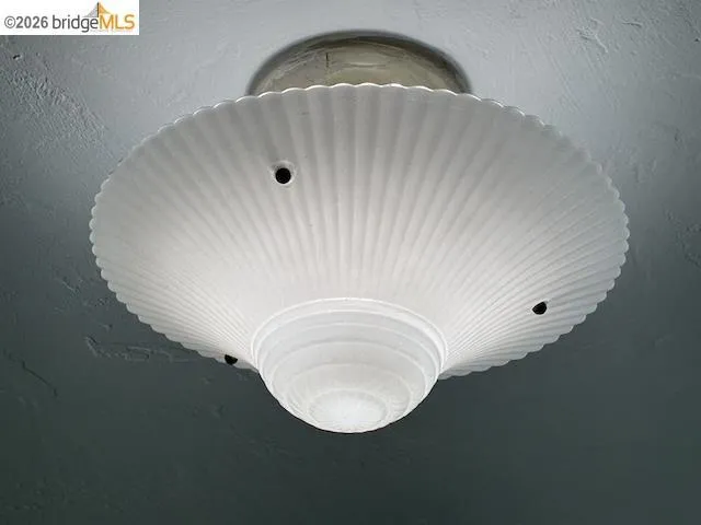 Flush-mount ceiling light with a frosted glass shade featuring a fluted, shell-inspired design