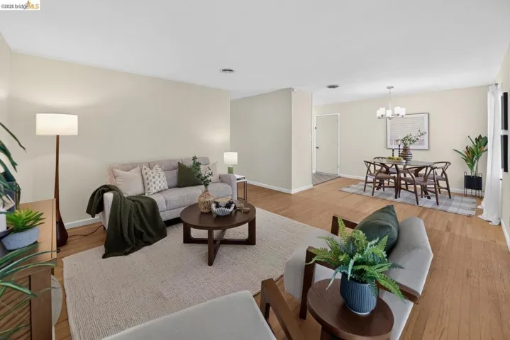 Open-concept living and dining areas featuring wood-finish flooring, recessed lighting, and neutral wall tones