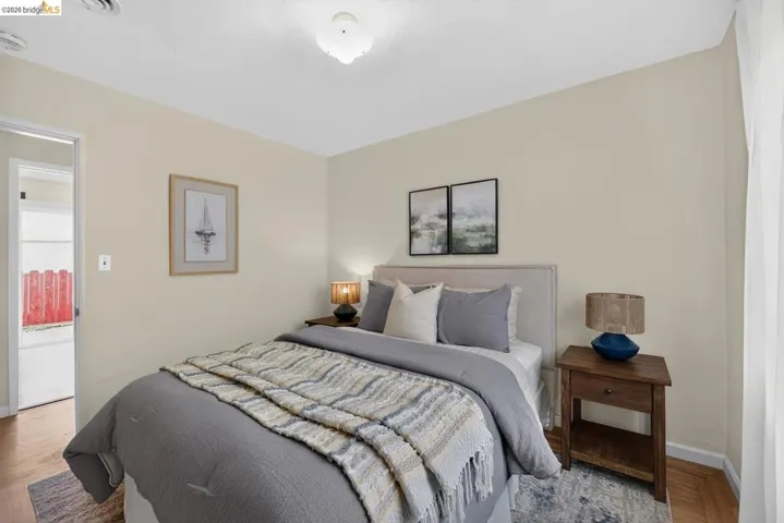 Bedroom featuring light neutral wall paint and wood-finish flooring