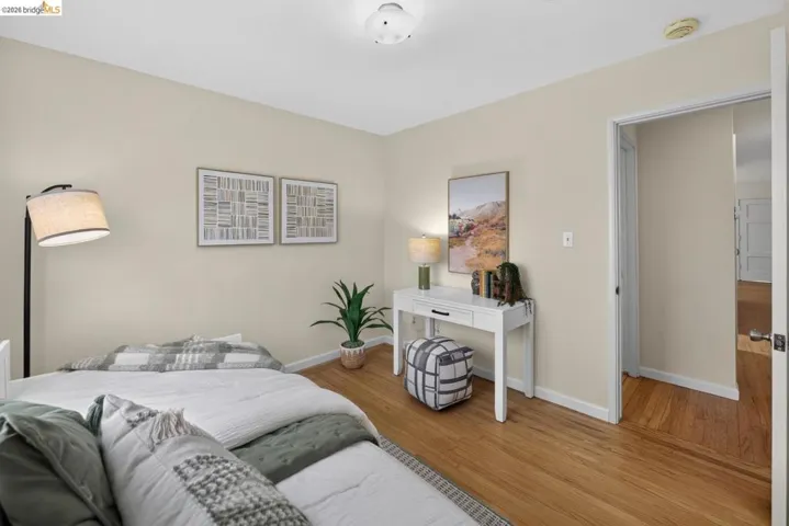 Bedroom featuring wood-finish flooring, neutral wall tones, and white trim