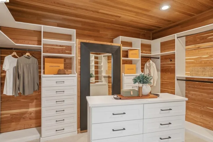 Custom cedar-lined closet featuring extensive built-in white cabinetry, integrated shelving, and multiple hanging rods