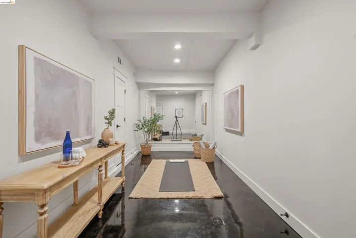 Long hallway featuring dark, polished flooring and recessed lighting