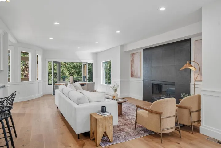 Open-concept living space featuring wood-finish flooring, recessed lighting, and white wainscoting