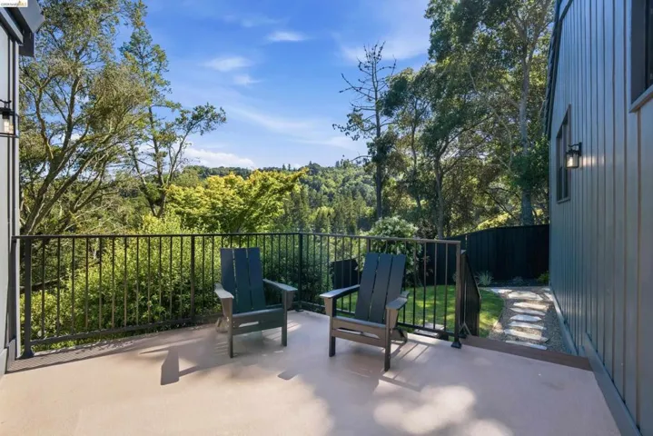 Outdoor deck featuring wood-finish flooring, black metal railings, and natural surroundings
