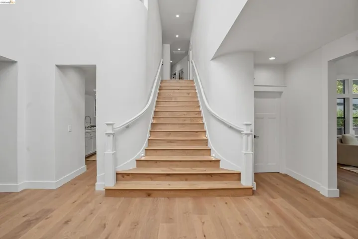 Grand curved staircase with wood-finish treads and white risers