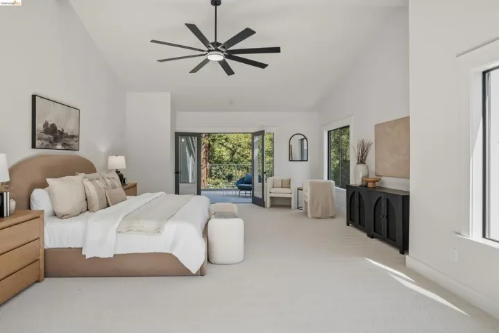 Vaulted ceilings accent this spacious room featuring a contemporary ceiling fan with integrated lighting
