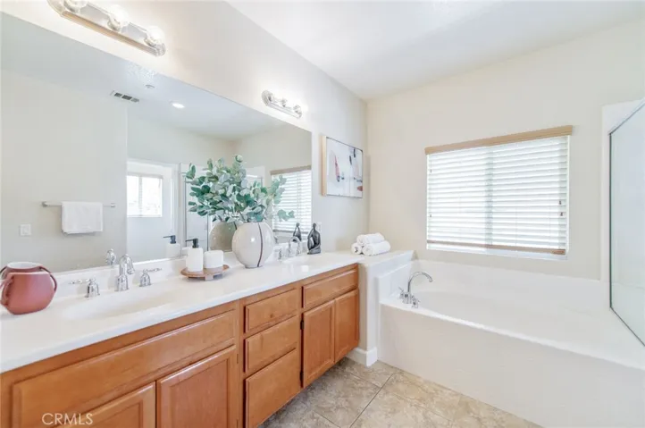 Master bath features dual vanities, a walk-in shower, a soaking tub, and two large walk-in closets