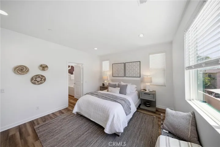 Primary bedroom with 3 windows bringing in a lot of natural light