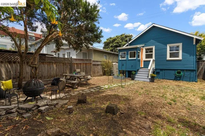 Rear exterior featuring blue siding, white trim windows, and a raised porch with white railings and steps