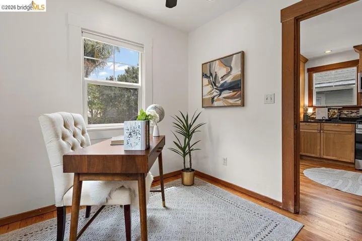 Inviting room featuring wood-finish flooring, a bright window, and a wood-trimmed doorway