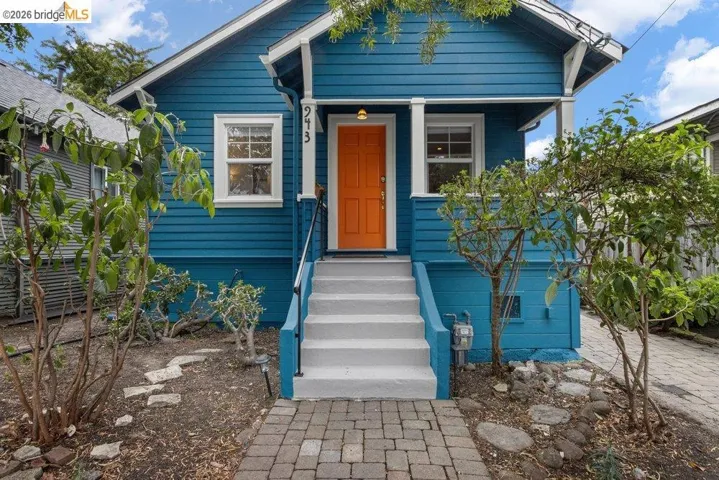 Vibrant blue exterior with white trim and an orange entry door