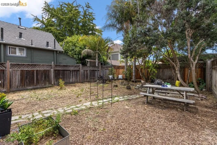 Expansive outdoor space featuring a wood chip ground cover, stone pathway, and mature trees