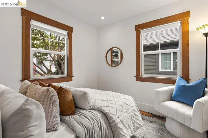 Bright room featuring two windows with wood trim, white walls, and recessed lighting