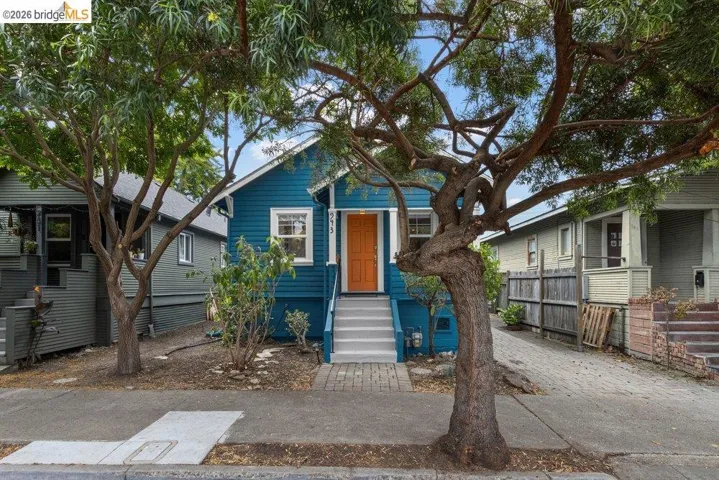 Blue exterior with white trim, featuring an orange front door and white-railed steps