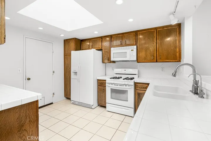 Tile counters and plenty of space in kitchen