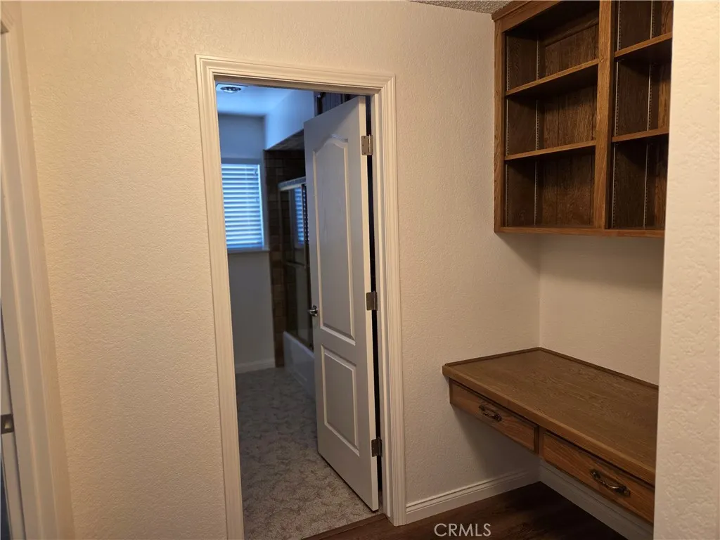 Hallway leading to front 2 bedrooms and full bath with desk area and shelves