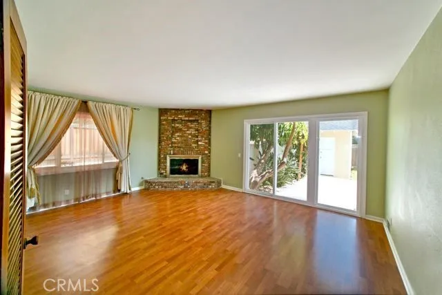 Open family room perfect for gatherings with a cozy, brick fireplace in the winter and easy access to private backyard entertainment in the summer.