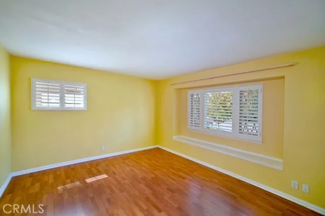 Secondary main floor bedroom with a built-in nook to view garden and additional shutters.
