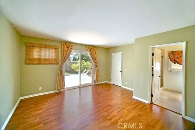 Main floor Primary bedroom featuring ensuite bath, walk-in closet, and accessibility to backyard.