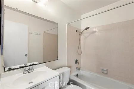 The bathroom has a shower over tub combination and a single sink vanity.