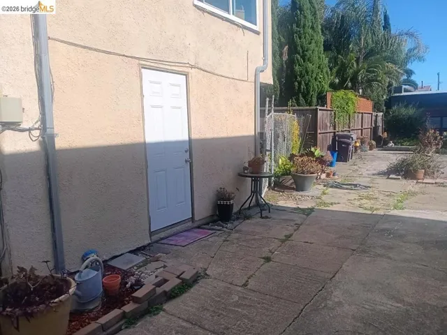 Concrete patio area bordered by a wood privacy fence
