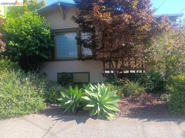 Stucco exterior with a pitched roofline and exposed rafter tails