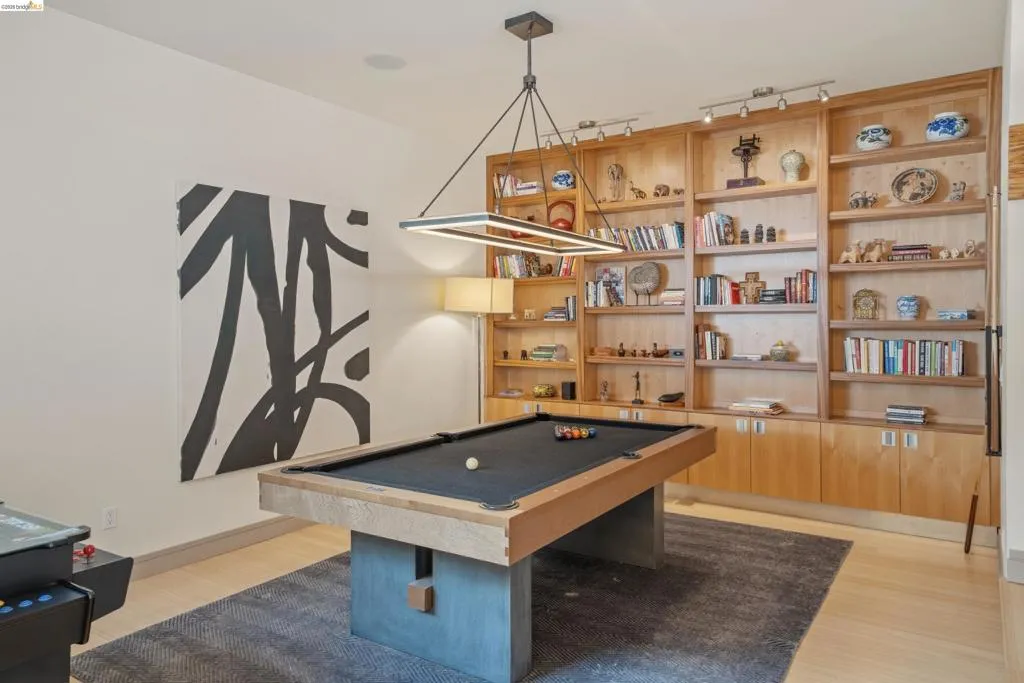 Entertainment room featuring a pool table with a black felt playing surface and concrete-style base