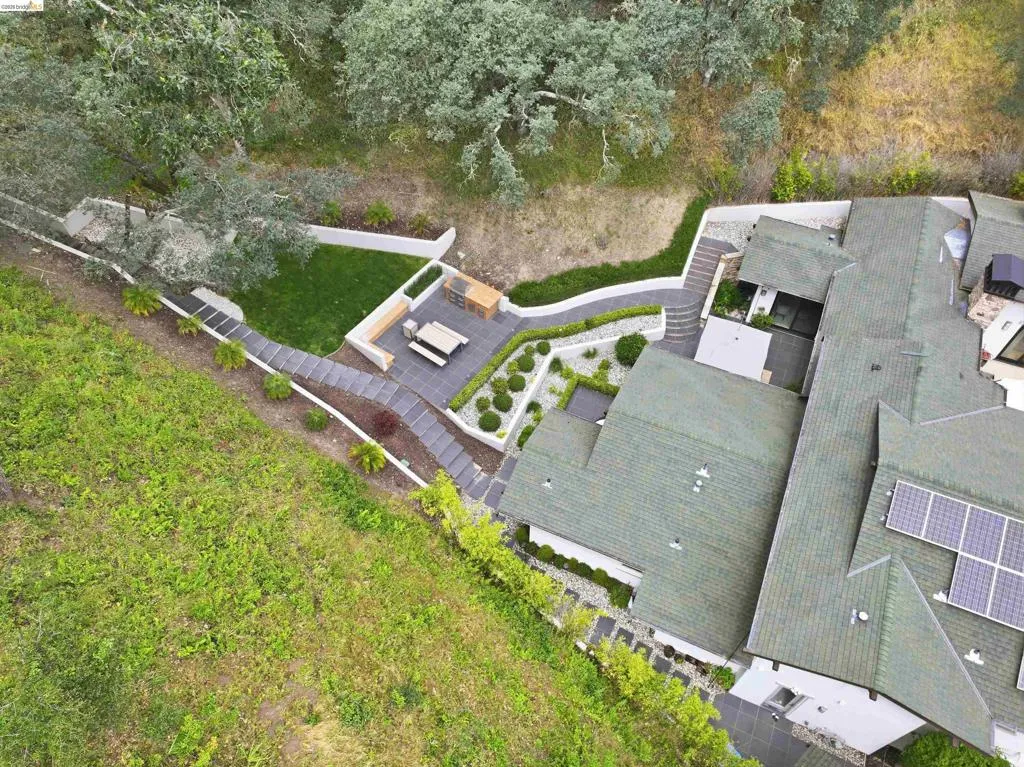 Tiered outdoor living space featuring paver stone patios, a manicured lawn area, and structured landscaping
