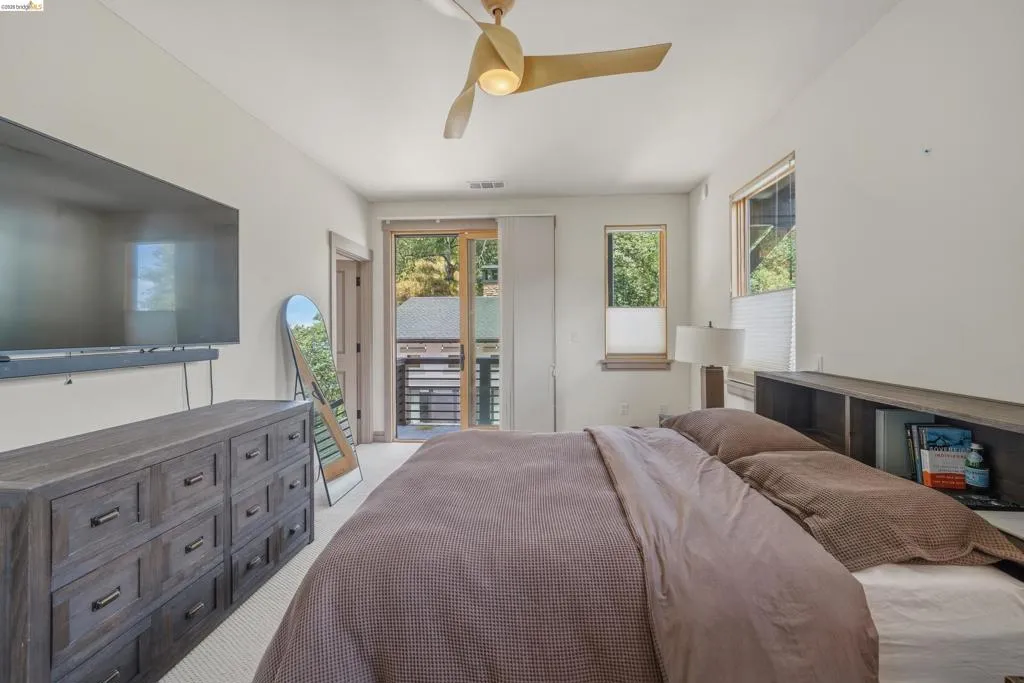Bright bedroom space featuring a contemporary ceiling fan and light-toned walls