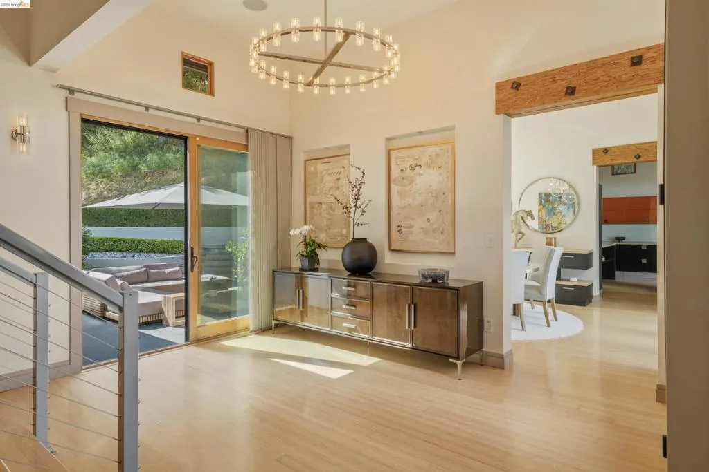 Entry foyer featuring light wood-finish flooring, a contemporary chandelier, and a built-in credenza
