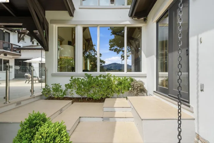 Exterior white stucco finish with dark-framed windows and an adjacent dark-framed glass door