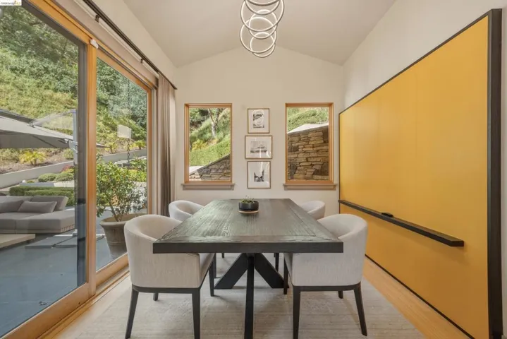 Dining area featuring a vaulted ceiling and a contemporary ring chandelier