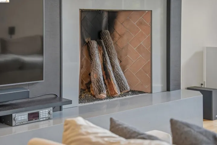 Contemporary fireplace featuring a herringbone brick interior and a stone hearth